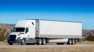 Truck Accident Lawyer Atlanta, GA - Eighteen wheel big rig tractor with trailer on highway. Trucking industry